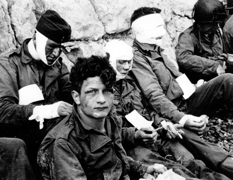 Раненные солдаты 1-й американской пехотной дивизии во время штурма Омаха-Бич. 6 июня 1944 г.