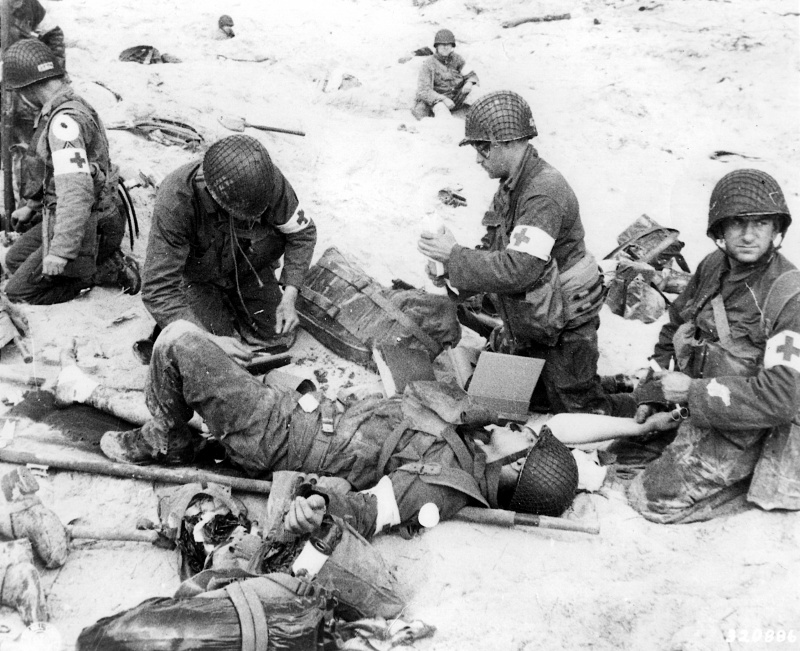 Медики оказывают помощь раненым американской 4-й пехотной дивизии на пляже Юта. 6 июня 1944 г.