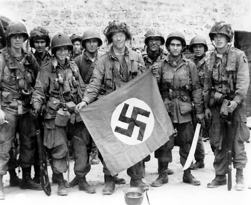 Американские десантники с захваченным нацистским флагом. Юта-Бич. 6 июня 1944 г.