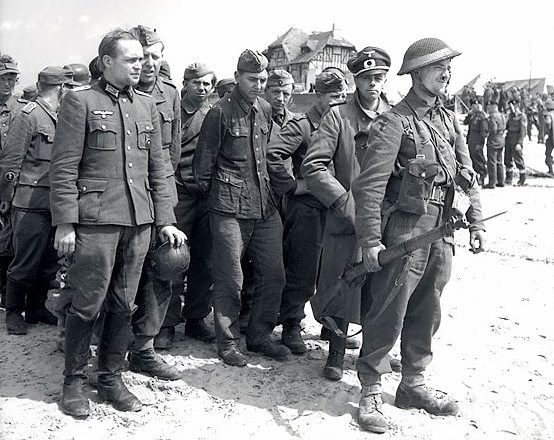 Пленные немцы под охраной канадского солдата. Курсель-сюр-Мер. 6 июня 1944 г. 