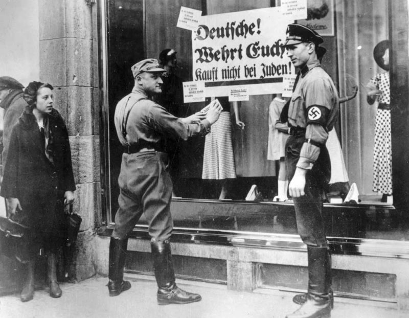 Плакат на витрине магазина гласит: «Немец остерегайся. Не покупай у евреев».