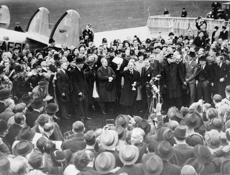 Невилл Чемберлен держит в руках документ, подписанный им и Гитлером по возвращении из Мюнхена на аэродроме Хестона. 