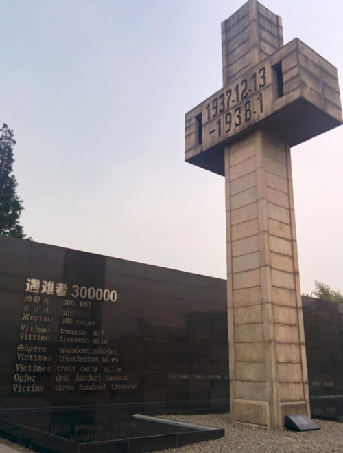 Стена Памяти, на которой написано на 12 языках - «Число жертв – 300 тысяч».