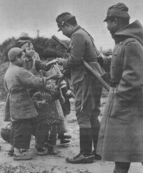 Японский офицер угощает конфетами китайских детей. 20 декабря 1937 г. Фото японской пропаганды.