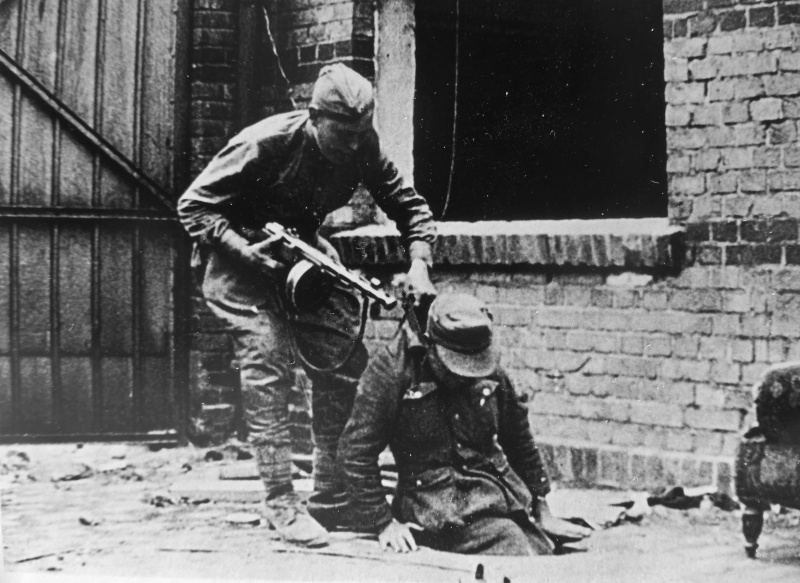 Советский солдат вытаскивает из люка немецкого солдата. Май 1945 г. 