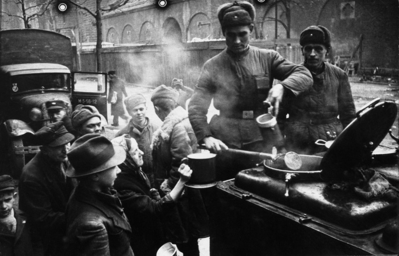 Советские бойцы у полевой кухни раздают пищу жителям Берлина. Май 1945 г. 
