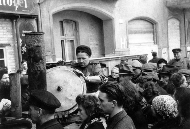 Советские бойцы у полевой кухни раздают пищу жителям Берлина. Май 1945 г. 
