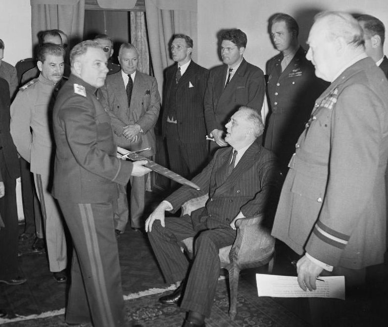 Маршал Климент Ворошилов показывает Сталинградский меч президенту США Франклину Рузвельту в зале заседаний Советского представительства в Тегеране. Иран, 28 ноября 1943 года.