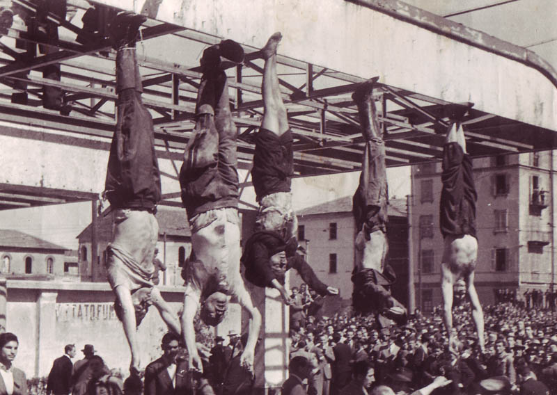Труп Муссолини (второй слева) рядом с Петаччи (в центре) и другими казненными фашистами на площади Лорето. 
