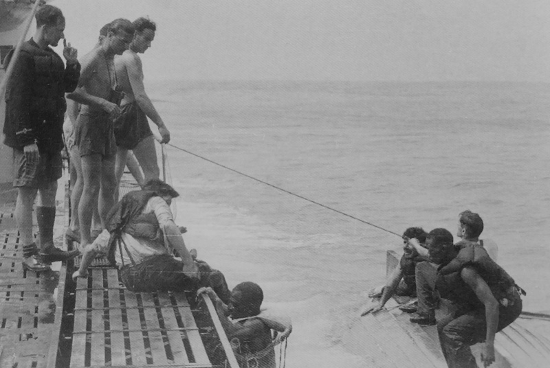 Немецкие подводники принимают на борт подлодки моряков потопленного британского транспорта. 1941 г. 
