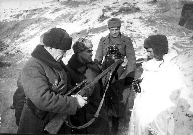 Командующий 62-й армии генерал-лейтенант В. И. Чуйков (слева) и член Военного совета генерал К. А. Гуров (в центре) осматривают винтовку снайпера Василия Зайцева. 1942 г. 