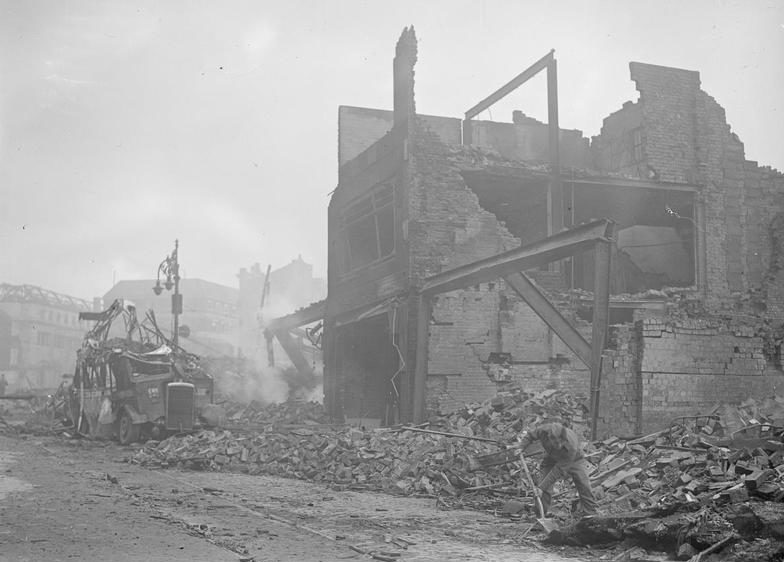 Военнослужащие вспомогательного военного корпуса разбирают дымящиеся завалы после бомбардировки. Ноябрь 1940 г.