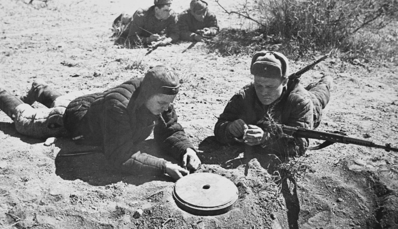 Советские саперы-разведчики обезвреживают немецкую противотанковую мину. 1942 г. 