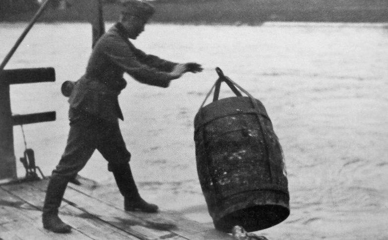 Немецкий солдат сбрасывает в Рейн бочку с пропагандистскими листовками на французском языке. Октябрь 1939 г. 
