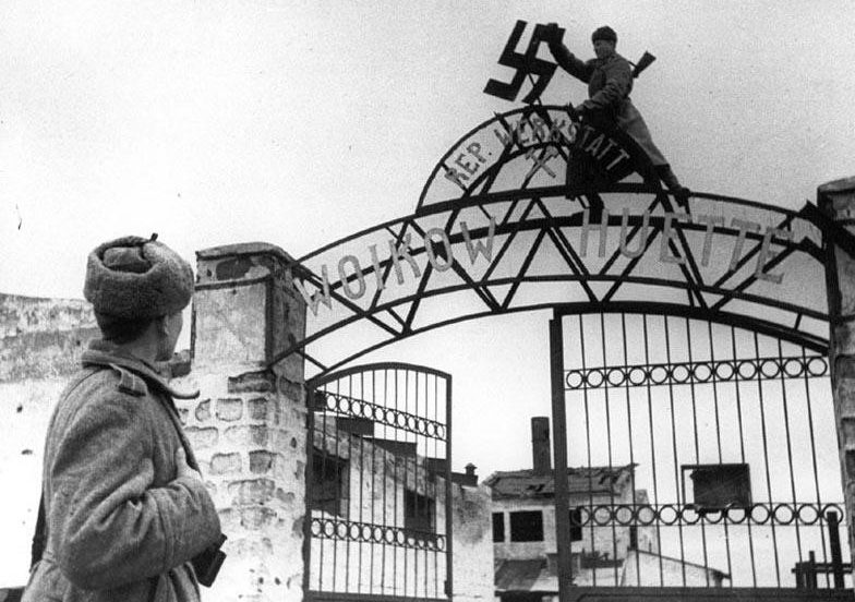 Красноармеец сбивает свастику с ворот завода им. Войкова. Керчь, апрель 1944 г. 