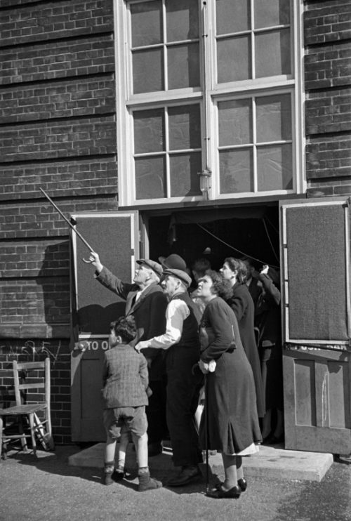 Жители Лондона наблюдают за немецкими самолетами у входа в бомбоубежище. 1940 г.