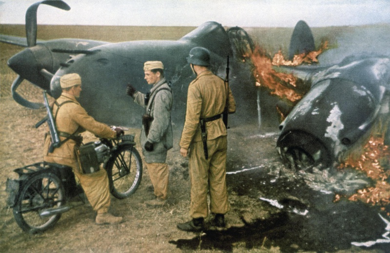 Немецкие солдаты у сбитого горящего американского истребителя P-38. 1943 г.