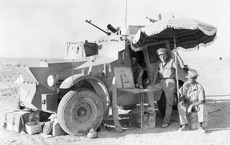 Британские офицеры 11-го гусарского полка с зонтиком во время перерыва в патрулировании на ливийской границе. 1940 г. 