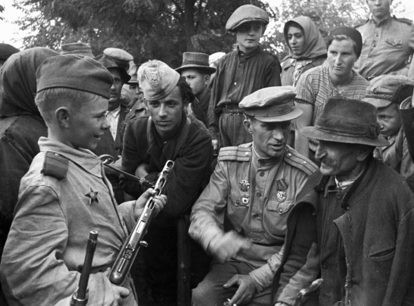 Советский офицер рассказывает жителям села о боевых заслугах Вити Жаворонка. 1943 г.