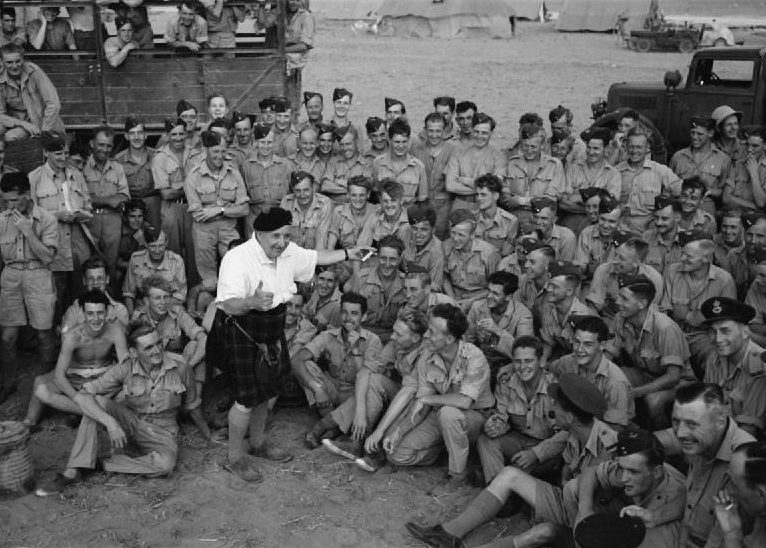 Уилл Файфф, известный шотландский комик, развлекает авиаторов на аэродроме в Хаммамете. 1943 г.