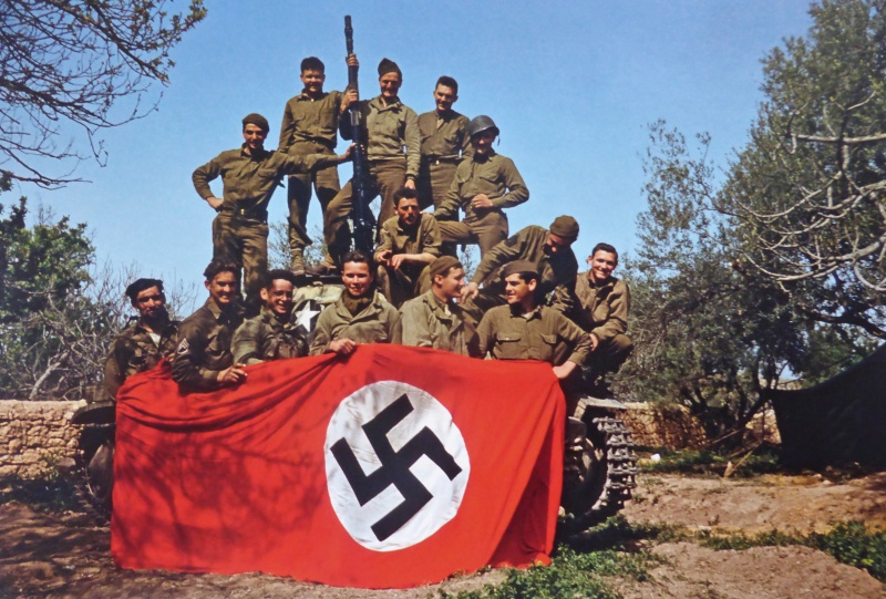 Американские солдаты позируют с немецким флагом. 1943 г.