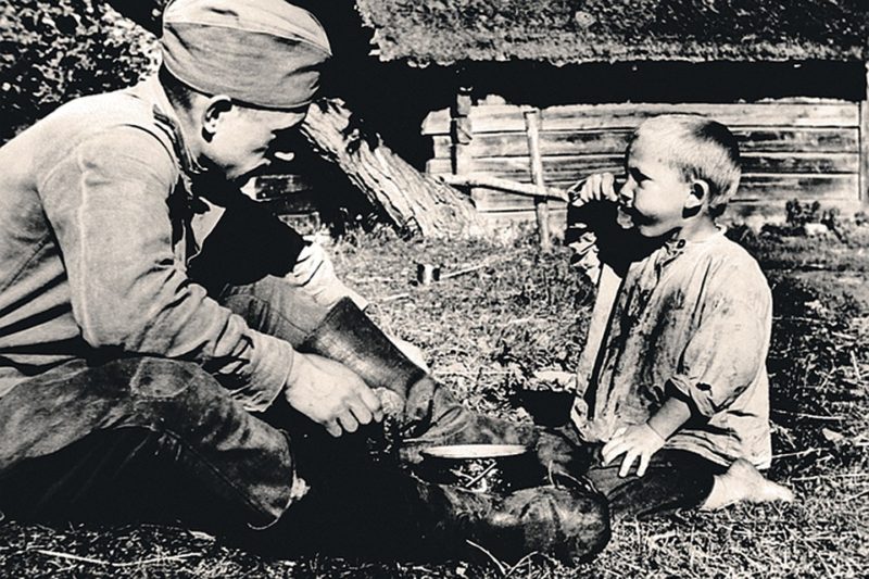Красноармеец кормит ребенка. Вильнюсская область, июнь 1944 г.