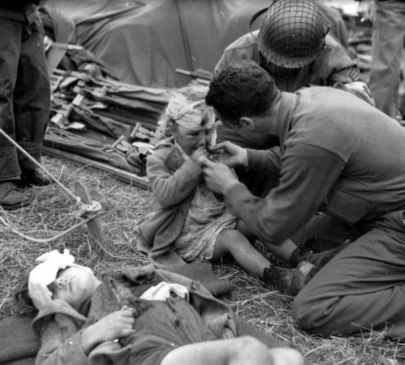 Американские медики и раненые французские дети в полевом госпитале. Июнь 1944 г. 