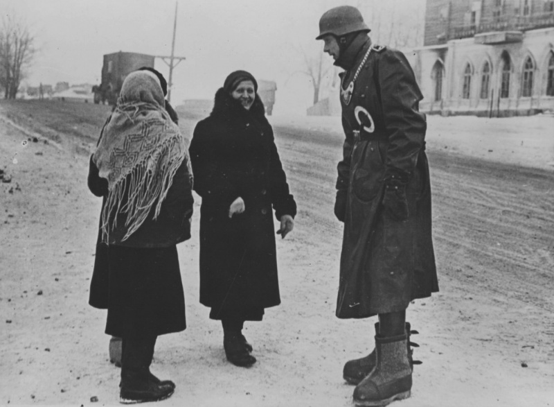 Солдат полевой жандармерии с женщинами на улице города. Ноябрь 1941 г. 