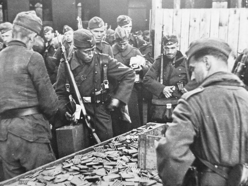 Немецкие солдаты сдают патроны на железнодорожном вокзале перед отправлением в отпуск. Сентябрь 1942 г. 