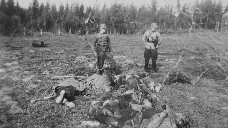 Финские солдаты у тел расстрелянных советских военнопленных. Октябрь 1941 г.