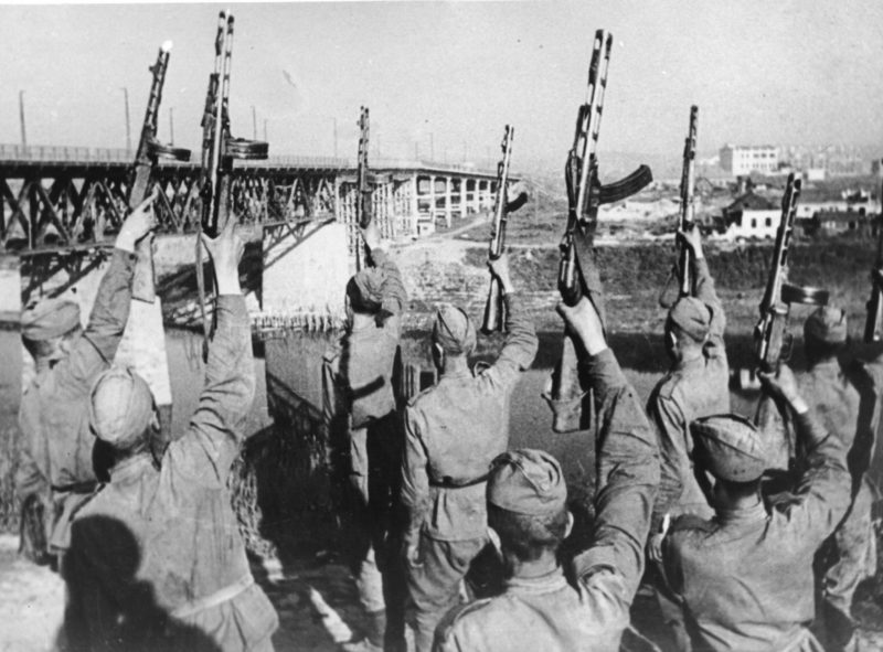 Советские солдаты салютуют освобождённому городу. 26 июня 1944 г.