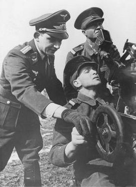 Немецкий инструктор обучает румынского солдата работе на зенитном орудии. Апрель 1941 г.