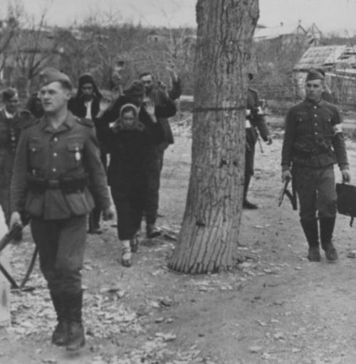 Немецкие солдаты конвоируют задержанных советских граждан на окраине Новороссийска. 1942 г.