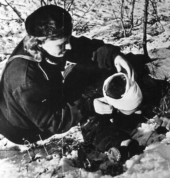 Военфельдшер перевязывает раненого красноармейца, во время боев на «Малой земле». Февраль 1943 г.