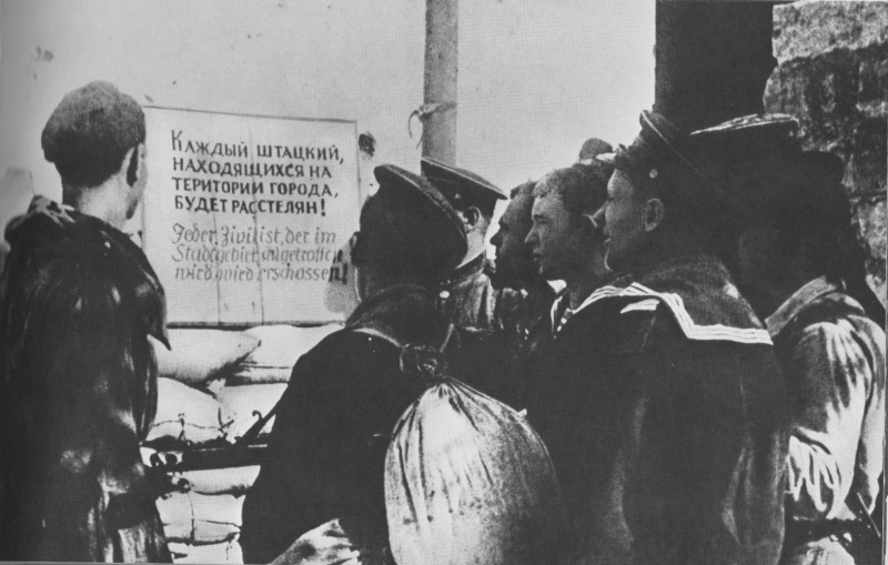 Краснофлотцы возле немецкого объявления в освобожденном Новороссийске. Октябрь 1943 г. 