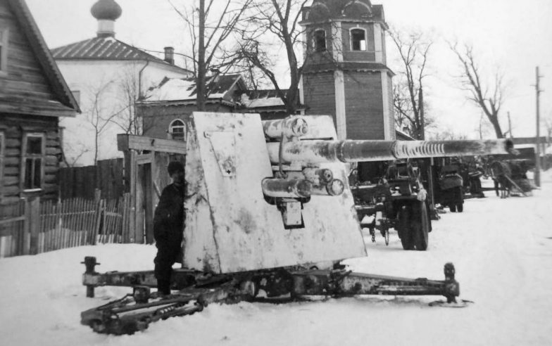 Солдат Вермахта возле 88-мм зенитного орудия, установленного на дороге в Демянске. Февраль 1942 г.
