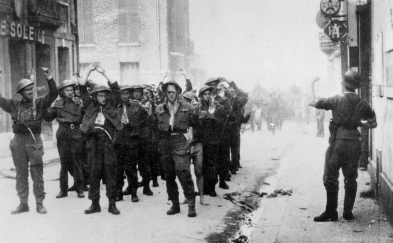 Немецкие солдаты отправляют группу канадских солдат в лагерь после битвы при Дьеппе. Август, 1942 г.