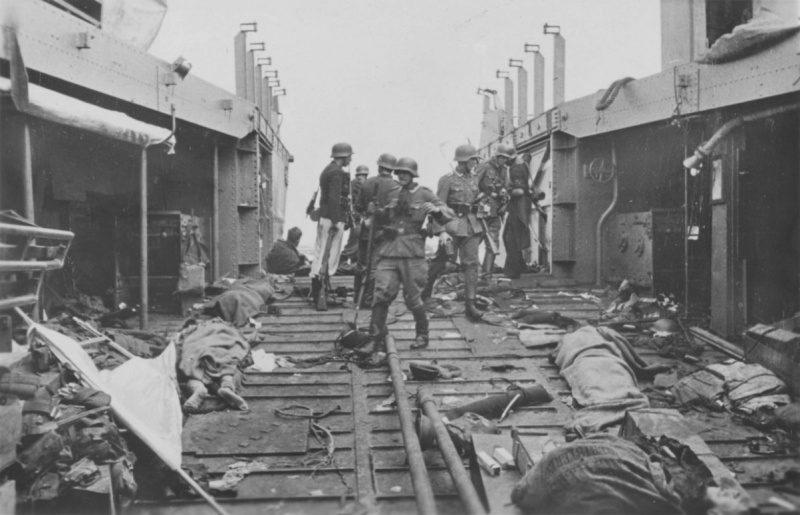 Немецкие солдаты осматривают десантный катер с телами убитых канадских и британских солдат в Дьеппе. Август 1942 г. 