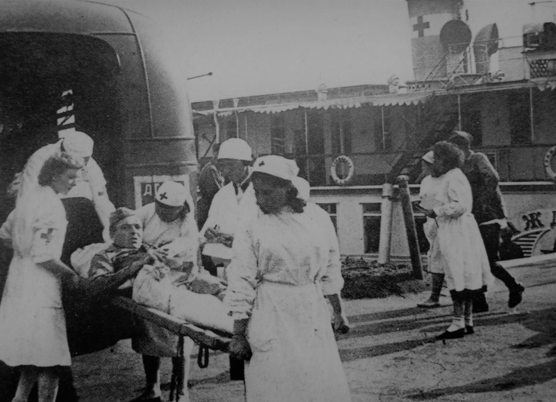 Переноска раненого красноармейца на носилках на берегу Волги к санитарному пароходу «Гражданин». 1942 г. 