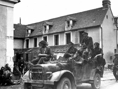Канадские солдаты из полка 10-й пехотной бригады перевозят немецких военнопленных во французском городке Трун. 1944 г. 