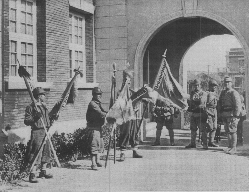 Японские солдаты с захваченными китайскими флагами в Нанкине. Декабрь 1937 г. 