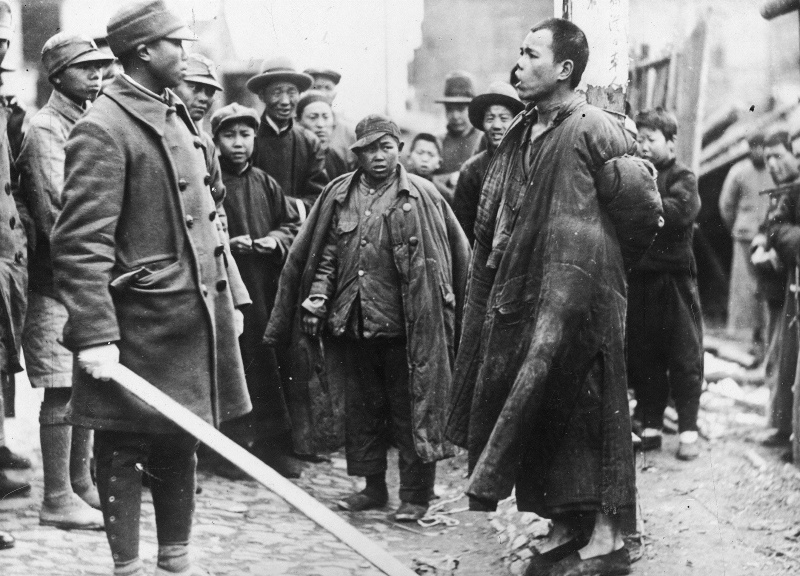 Офицер армии Гоминьдана допрашивает китайца, обвиненного в шпионаже в пользу японцев. 1938 г. 