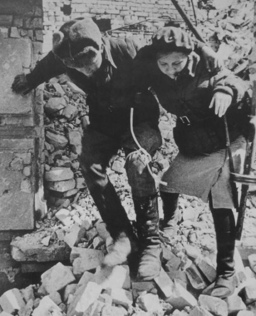 Девушка-санинструктор сопровождает раненого солдата. Октябрь 1942 г.