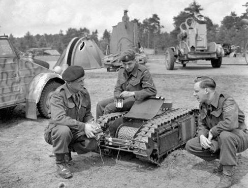 Канадцы рассматривает немецкую дистанционную мину «Голиаф». Нидерланды, 12 июня 1945 г.