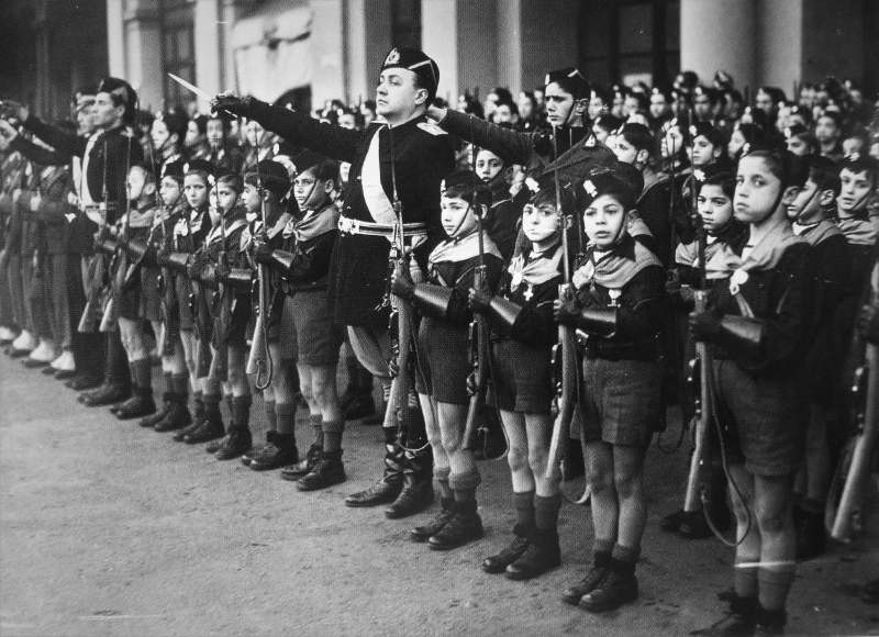 Дети из итальянской молодежной фашисткой организации «Итальянская ликторская молодежь» приветствующие премьер-министра Великобритании Чемберлена во время его визита в Рим. Январь 1939 г. 