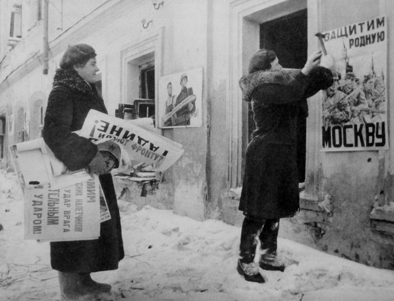 Девушки прибивают агитплакаты на улице освобожденного Можайска. Январь 1942 г.