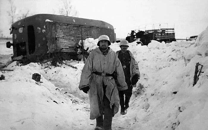Немецкие солдаты на фоне разбитой штабной колонны. Март 1942 г.