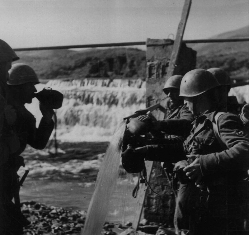 Итальянские солдаты наполняют фляжки водой у водопада в Албании. Май 1941 г. 