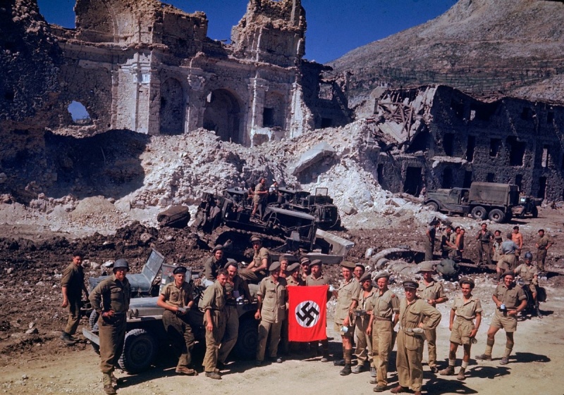 Солдаты союзников с захваченным нацистским флагом на руинах города в Италии. 1944 г. 