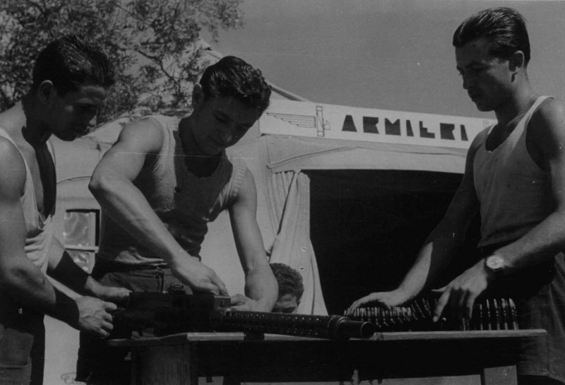 Итальянские оружейники обслуживают авиапулемет на Сицилии. Август 1941 г. 